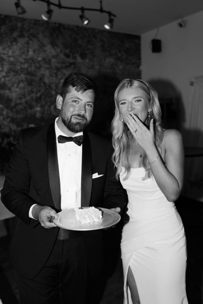 couple eating wedding cake black and white flash reception